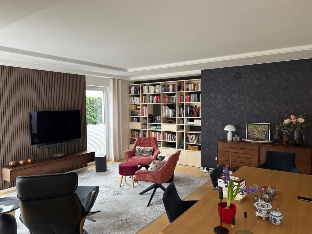 Modernes Wohnzimmer mit Loungesesseln und TV-Wand aus Lamellen und Akzentwand in Anthrazit